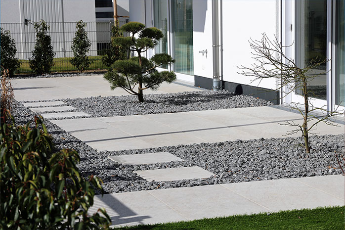 Aménager une terrasse moderne avec du béton, de la pierre et des plantations parcimonieuses